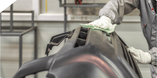 a person cleaning the front bumper of a car