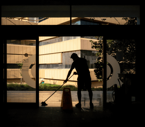 a silhouette of a man mopping the floor